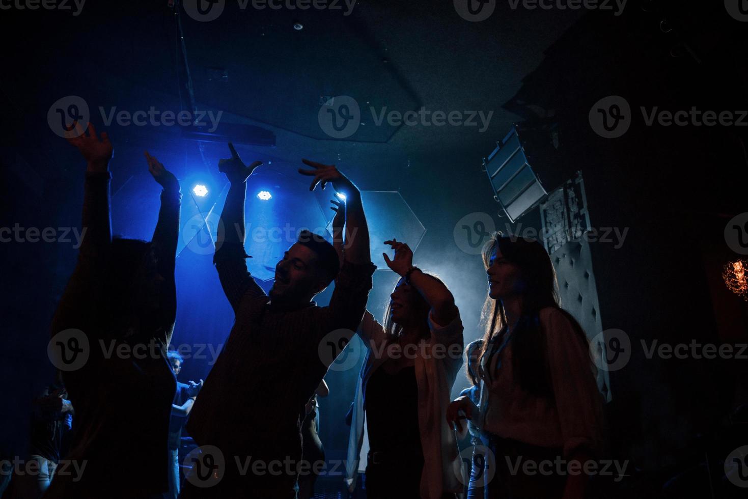 groep mensen die genieten van dansen in de nachtclub met prachtige verlichting foto