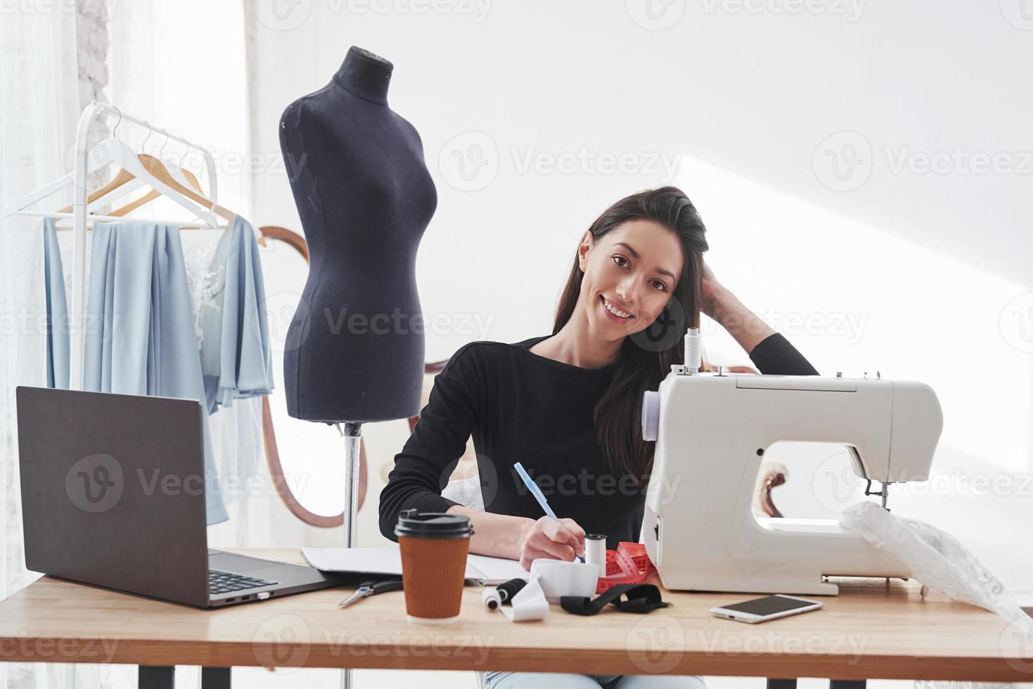 verliefd op haar werk. vrouwelijke modeontwerper werkt aan de nieuwe kleren in de werkplaats foto