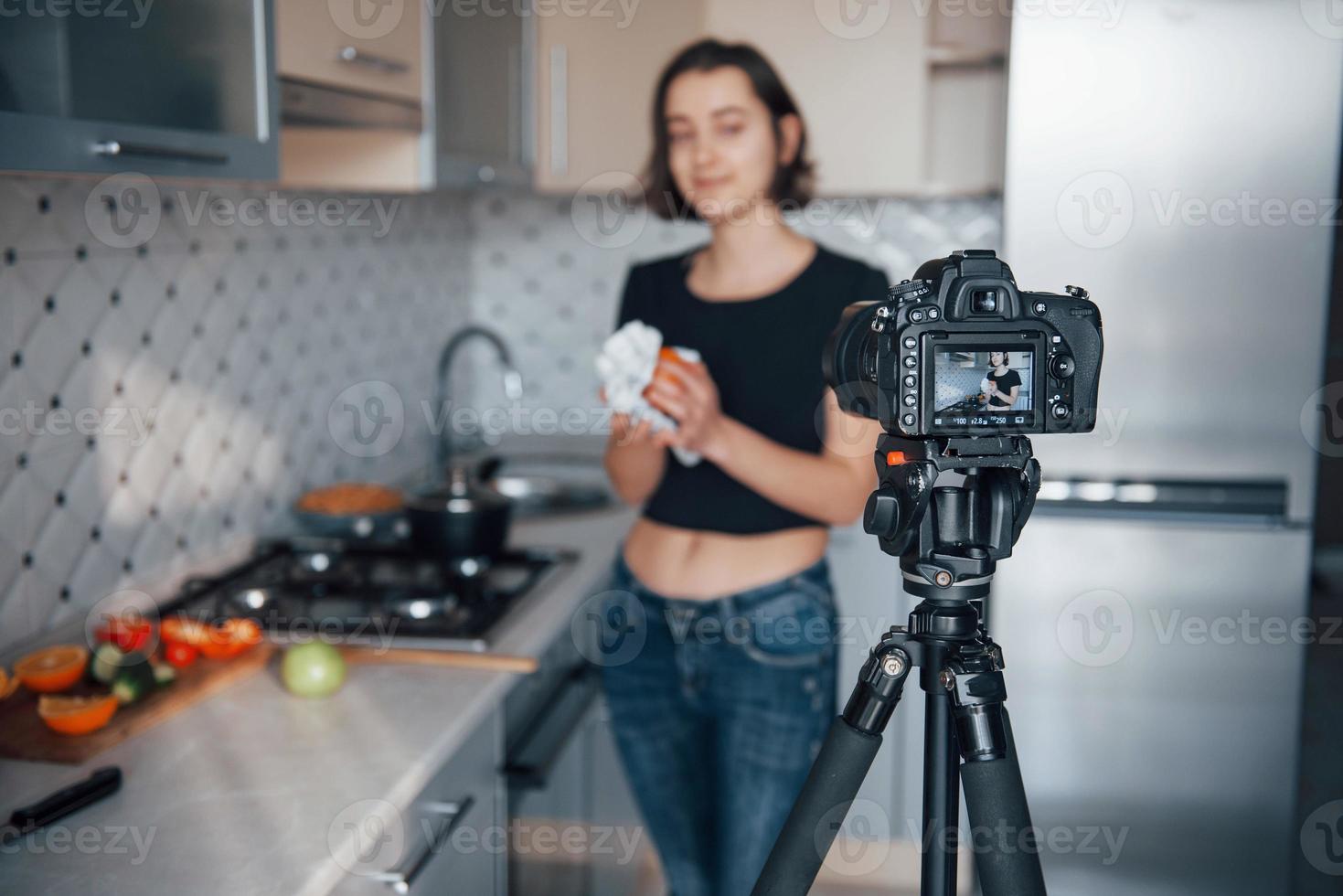 het schoonmaken van de sinaasappel. meisje in de moderne keuken thuis in haar weekendtijd in de ochtend foto