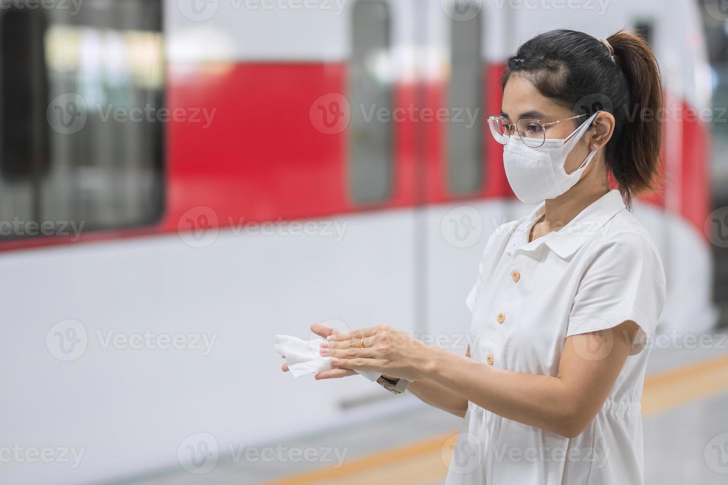 vrouw schone hand door nat doekje in het openbaar vervoer, bescherming coronavirus ziekte infectie. veiligheidsreizen en persoonlijke hygiëne concepten foto