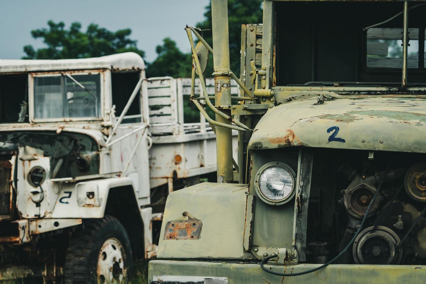 oude vernielde witte en groene vrachtwagen. verlaten roestige militaire vrachtwagen. vervallen verlaten vrachtwagen. tragedie en verlies. financiële crisis en economisch recessieconcept. oude vervallen vrachtwagens. vervoer. foto