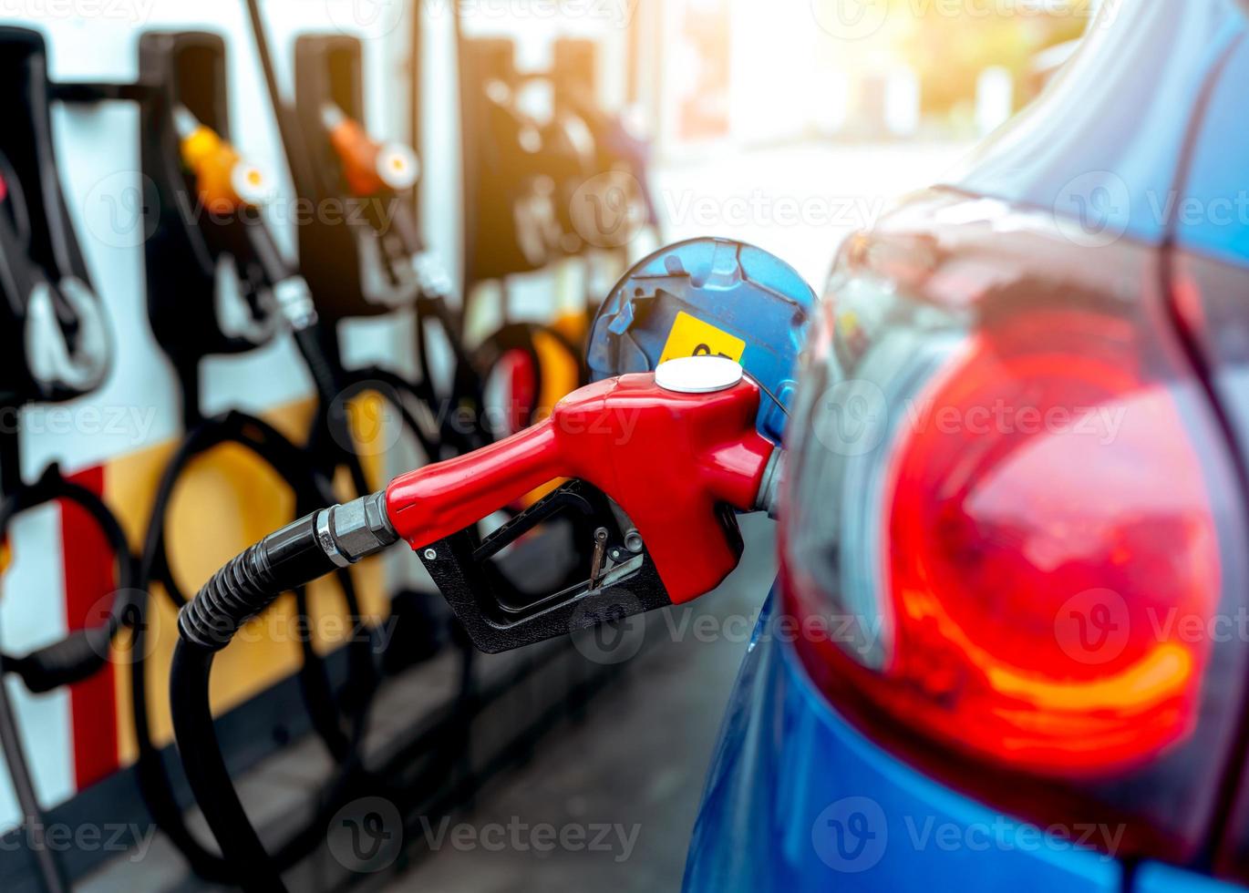 auto tanken bij tankstation. tanken tanken benzine benzine. benzinepomp die brandstofmondstuk in brandstoftank van auto bij benzinestation vult. benzine-industrie en service. benzineprijs en oliecrisisconcept. foto