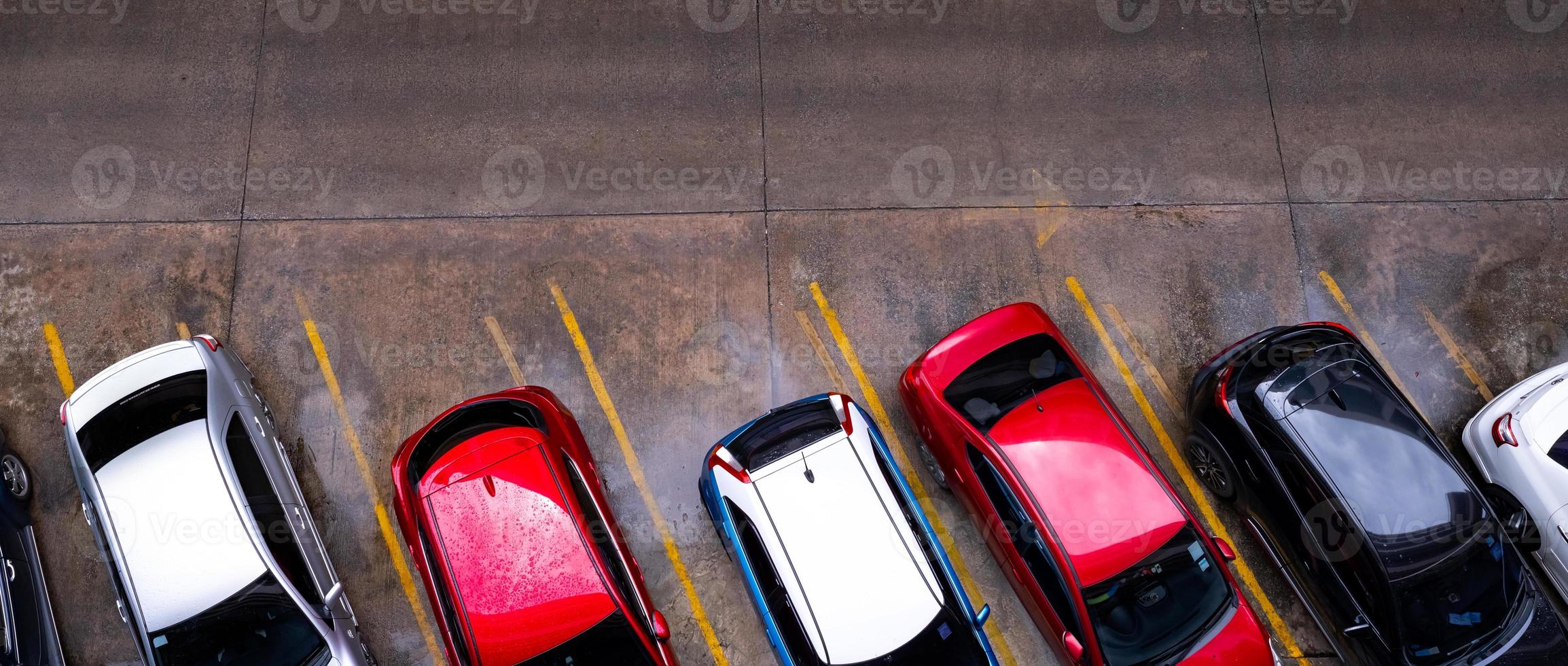 bovenaanzicht van auto geparkeerd op betonnen parkeerplaats met gele lijn van verkeersbord op straat. boven weergave van auto op een rij op parkeerplaats. geen beschikbare parkeerplaats. buiten parkeerplaats. foto