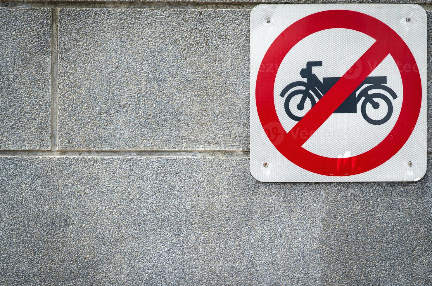 motorfiets geen toegangsbord installeren op betonnen muur voor tunnel onder weg. verkeersbord om motorfiets te verbieden. beperkende tekens. motorfiets voorzichtigheid en stop met rijden naar deze manier. motor verbieden foto