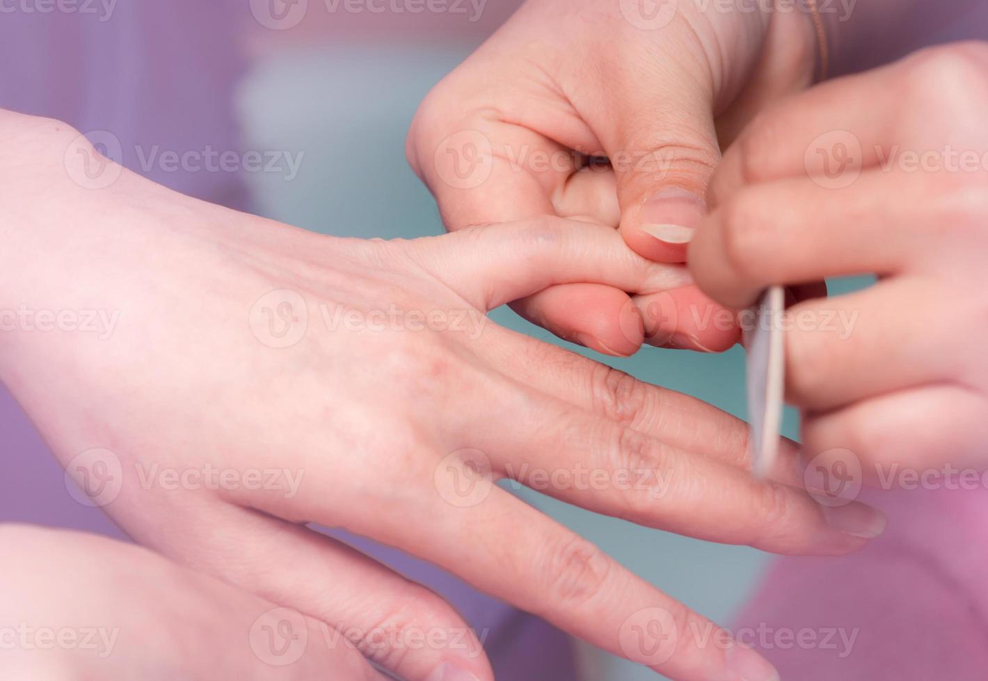 vrouw die vingernagel manicure service ontvangt door professionele manicure bij nagelsalon. schoonheidsspecialiste bestand nagel manicure bij nagel en spa salon. handverzorging en nagelbehandeling bij nagelsalon. foto