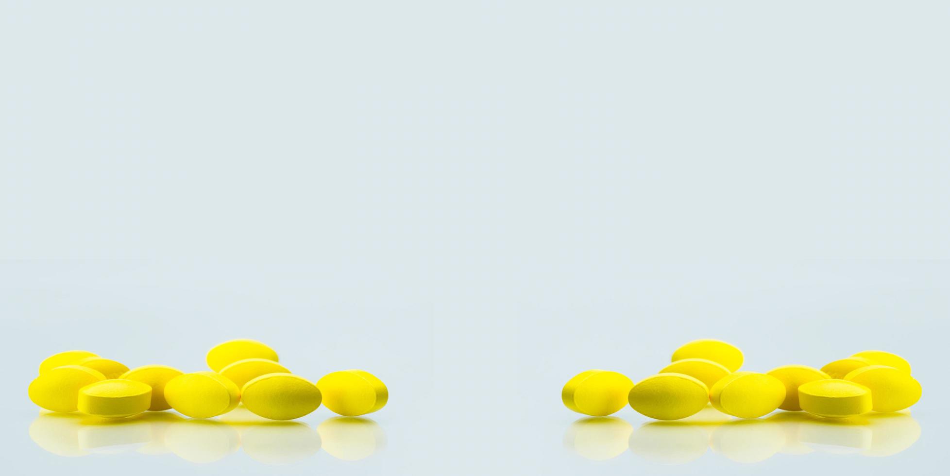 gele ovale tablet pillen met schaduwen op witte achtergrond met kopie ruimte voor tekst. milde tot matige pijnbestrijding. pijnstillend medicijn. foto