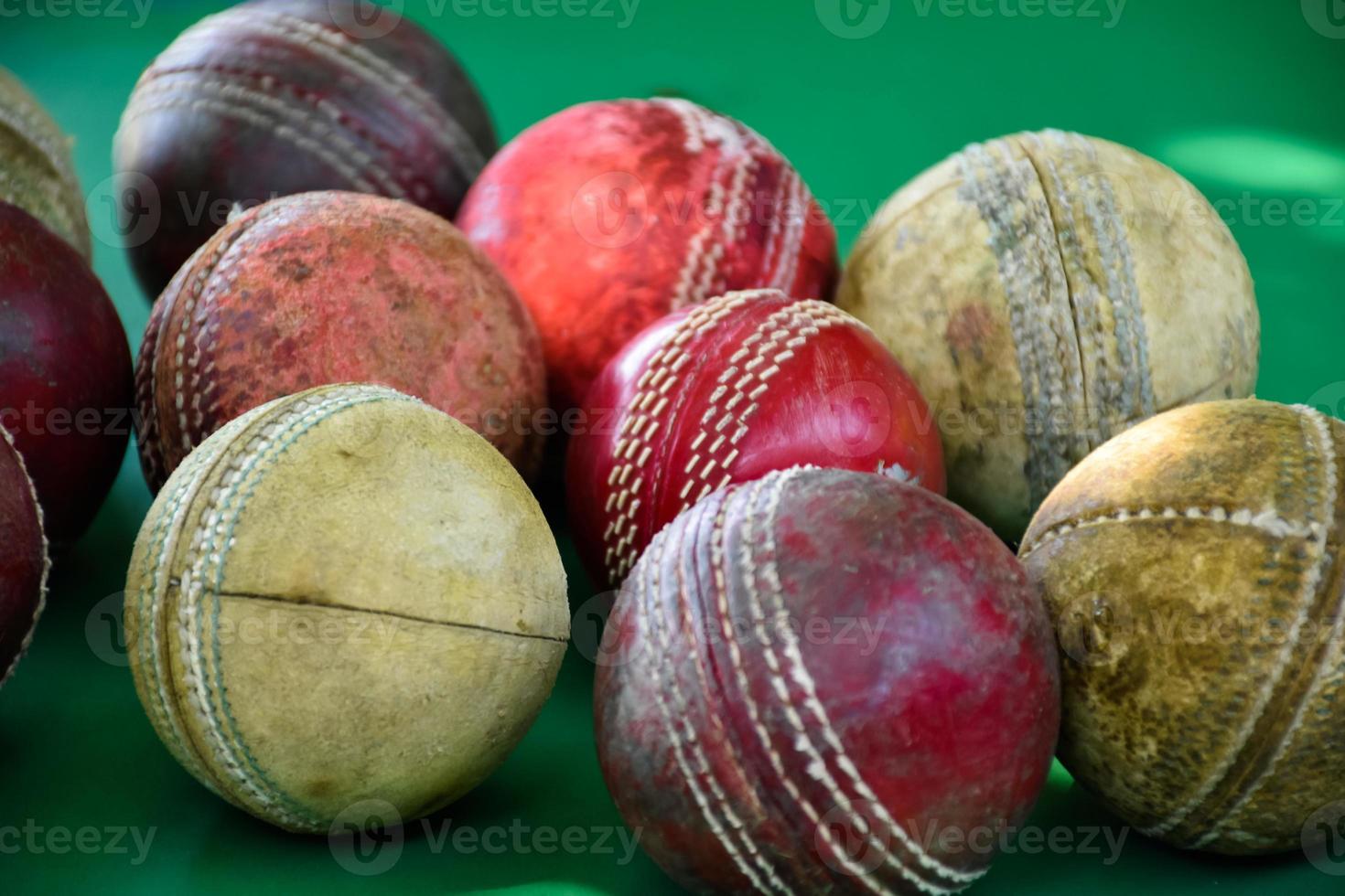 close-up oude en gebruikte lederen cricketballen op groene vloer, zachte en selectieve focus. concept voor cricketliefhebber over de hele wereld. foto