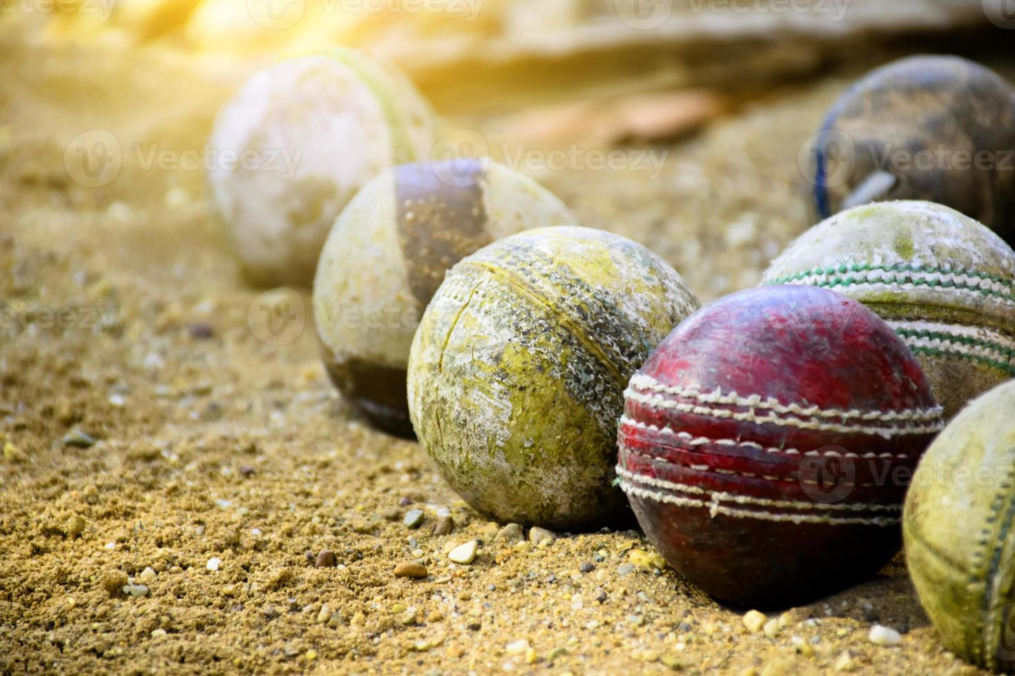 oude leren cricketballen voor training en oefenen op zandvloer naast het veld, zachte en selectieve focus op rode cricketbal. foto