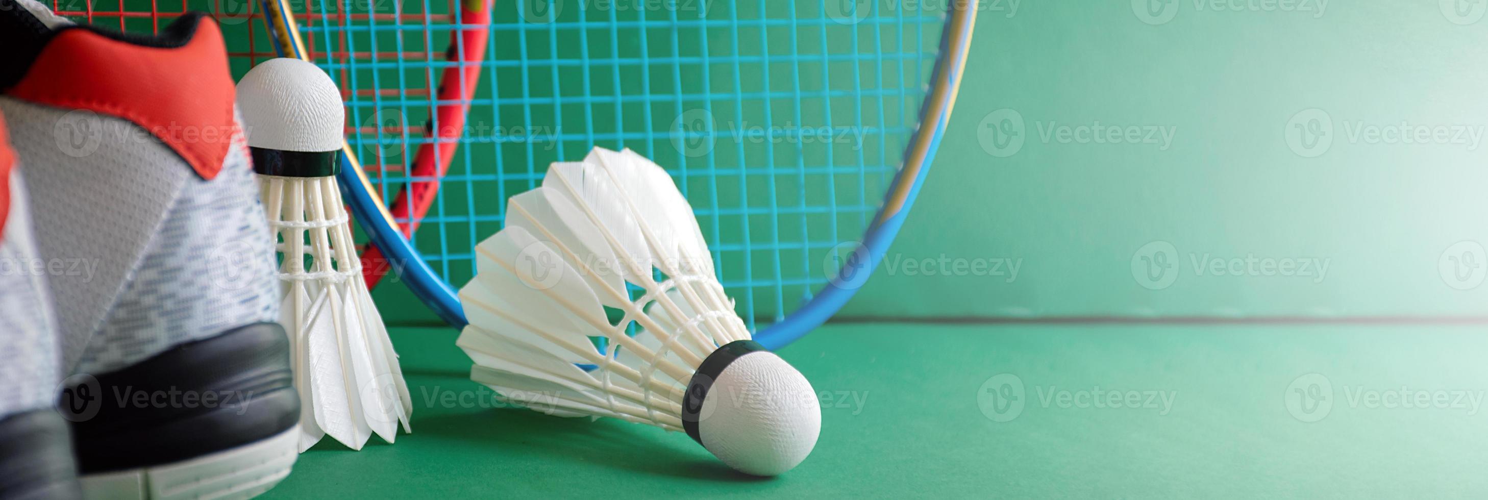 badmintonsportuitrusting op groene vloer van badmintonveldshuttles, rackets, schoenen, selectieve focus op shuttles, badmintonsportliefhebber over het hele wereldconcept. foto