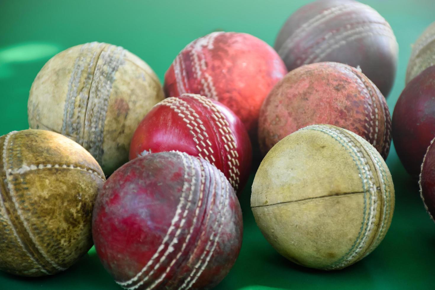 close-up oude en gebruikte lederen cricketballen op groene vloer, zachte en selectieve focus. concept voor cricketliefhebber over de hele wereld. foto