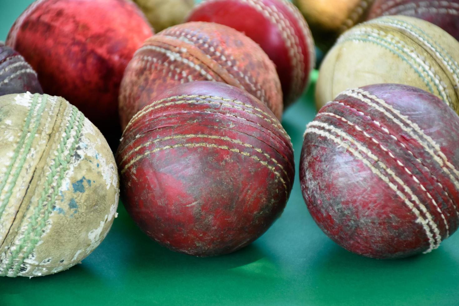 close-up oude en gebruikte lederen cricketballen op groene vloer, zachte en selectieve focus. concept voor cricketliefhebber over de hele wereld. foto