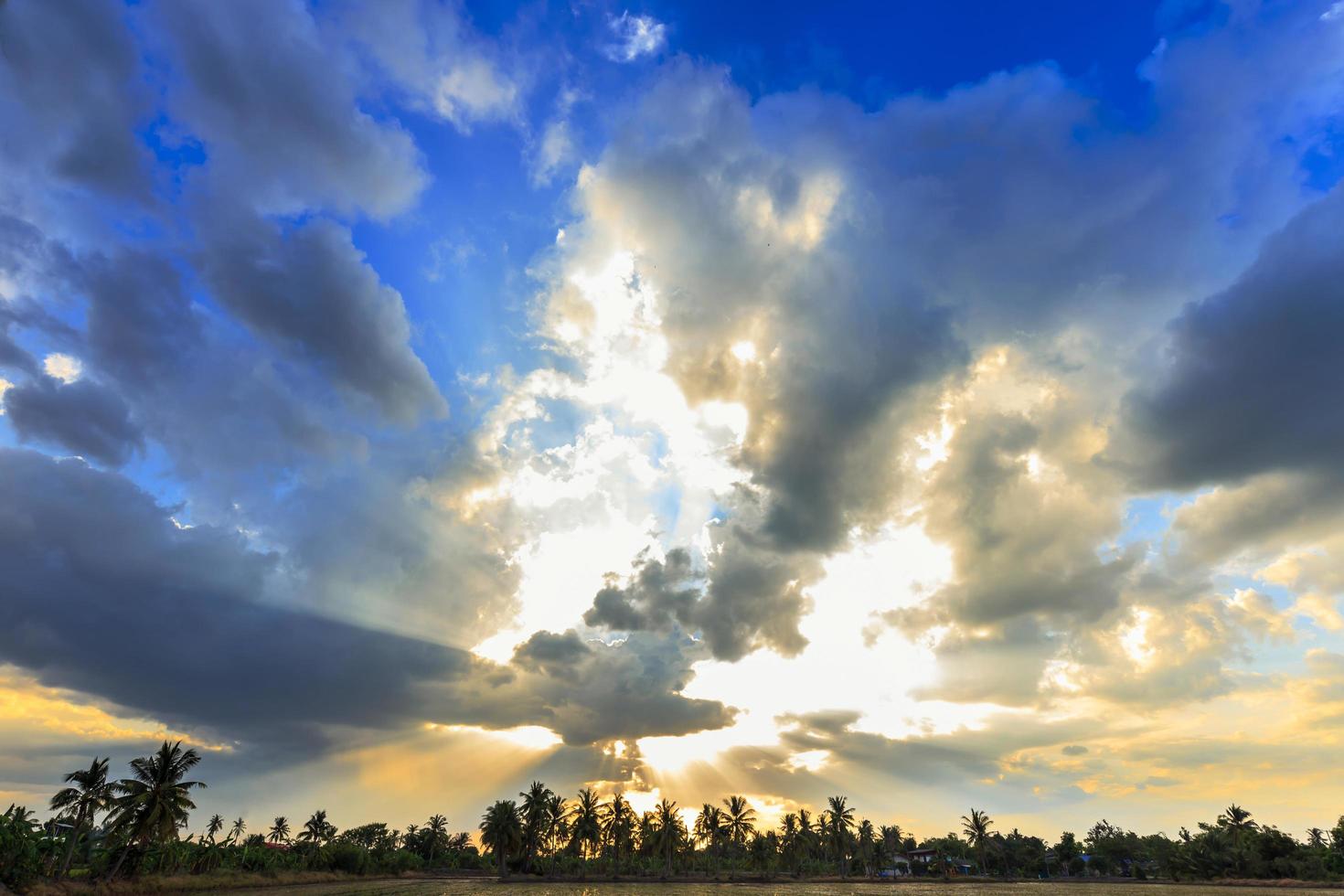 lichtstraal breekt door de dramatische lucht bij zonsondergang foto