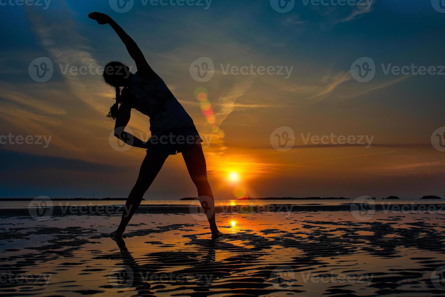 meisje alleen fitnessoefening in een zonsopgang op het strand foto