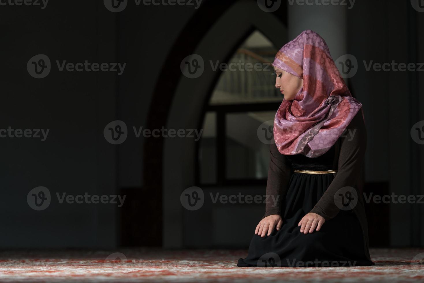 jonge moslimvrouw bidden in de moskee foto
