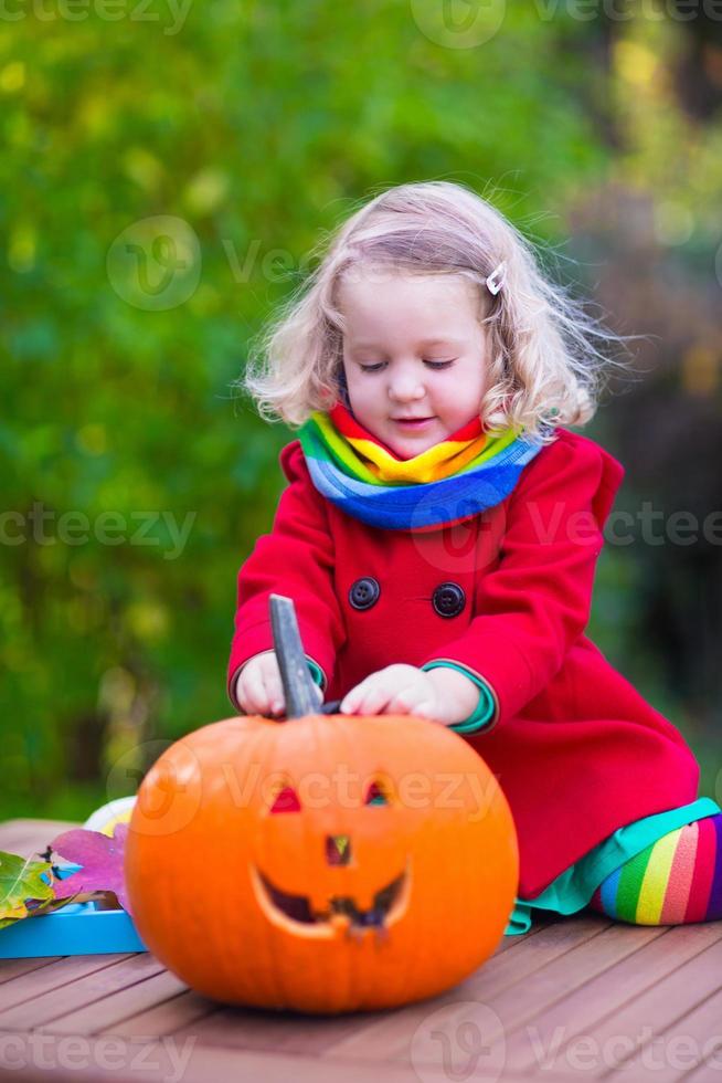 kinderen snijwerk pompoen op halloween foto