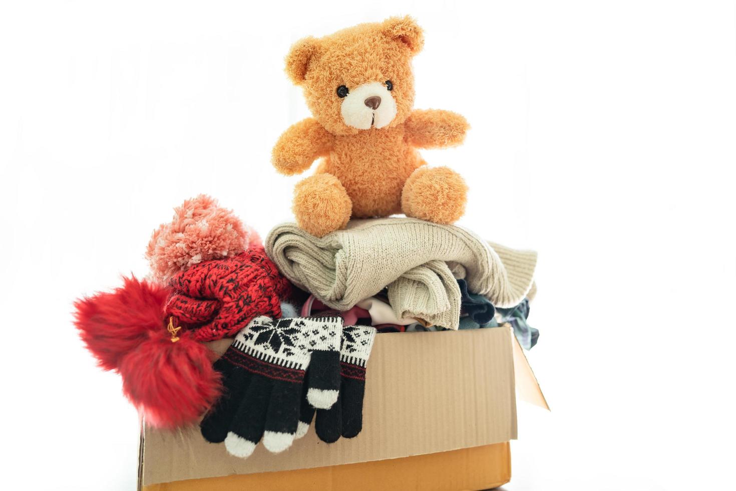 donatiebox met gebruikte kleding en teddybeer thuis om hulp te bieden aan arme mensen in de wereld. foto