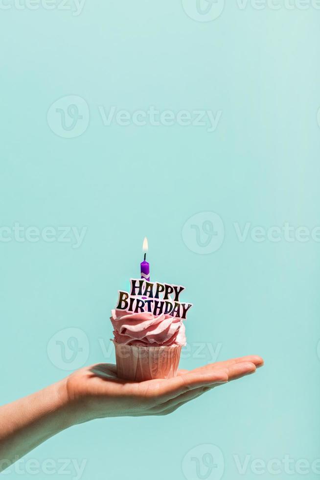 vrouw hand met verjaardag cupcake met kaars. foto