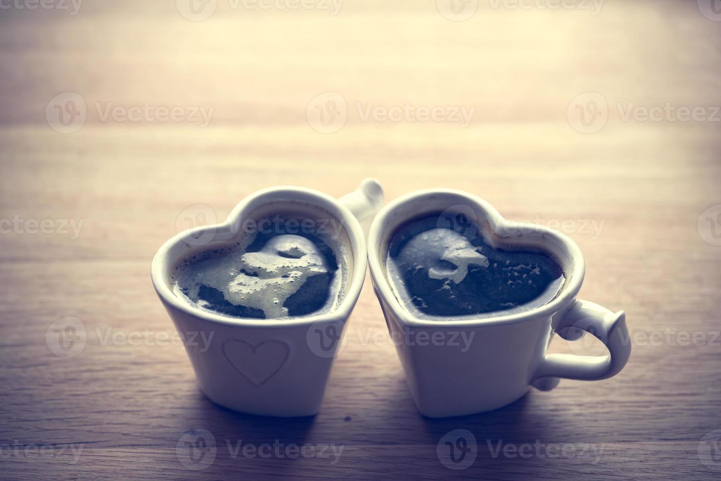 zwarte koffie, espresso in twee hartvormige kopjes foto