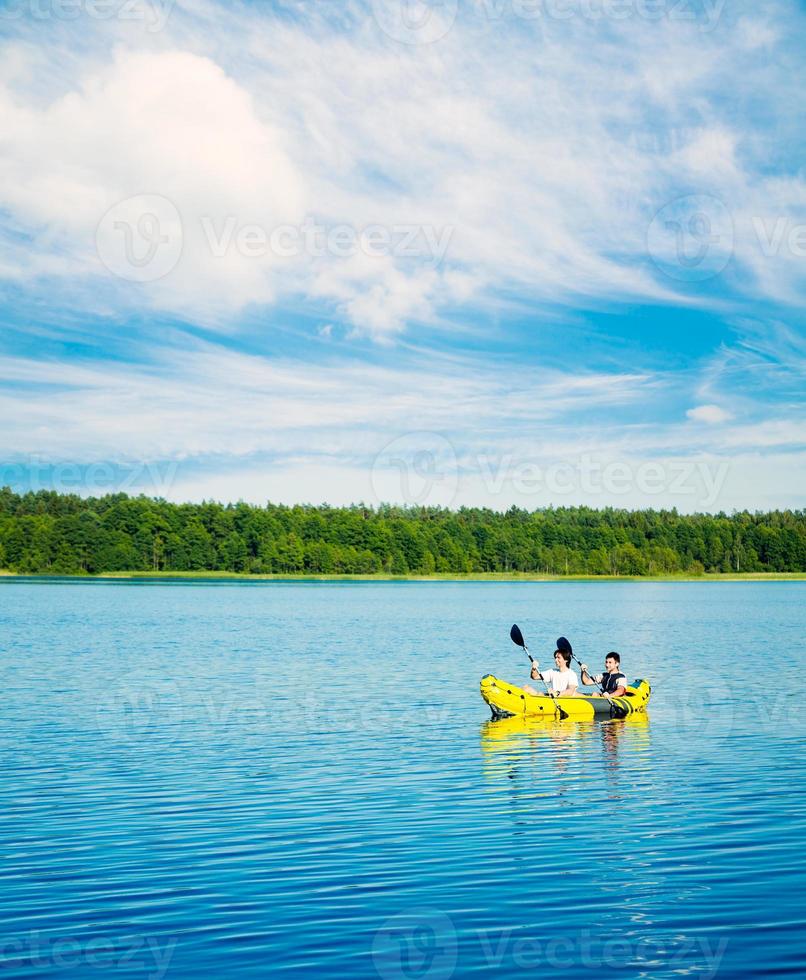 twee mannen peddelen een kajak op het meer. levensstijl concept. foto