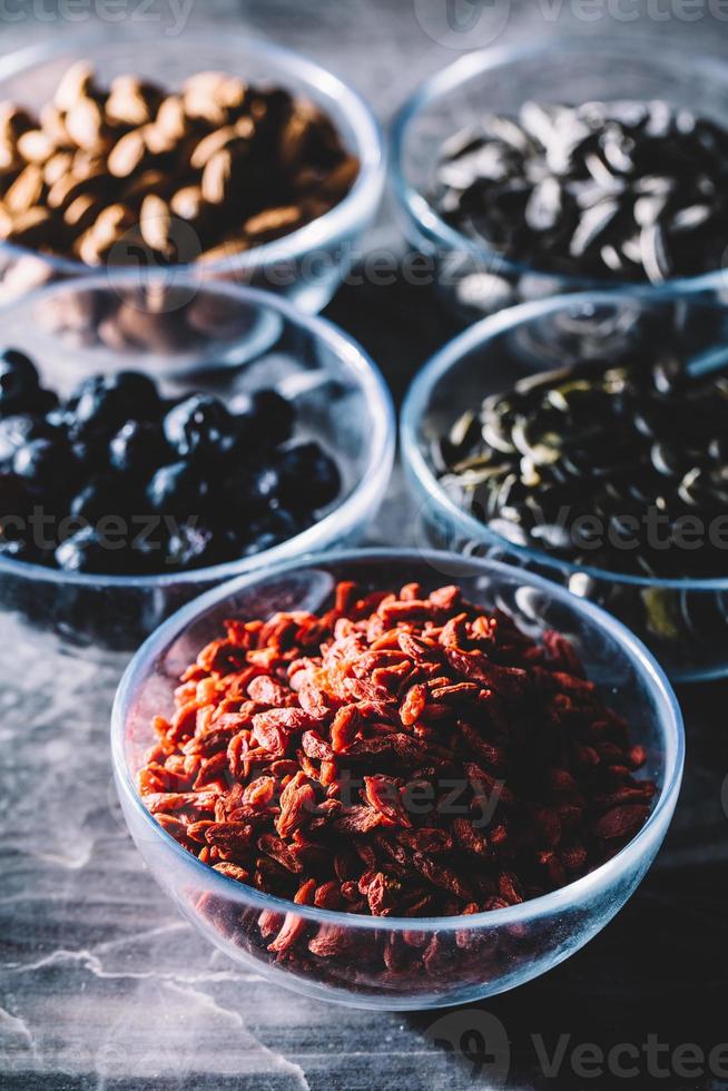 gezonde veganistische snacks in vijf transparante glazen kommen. foto