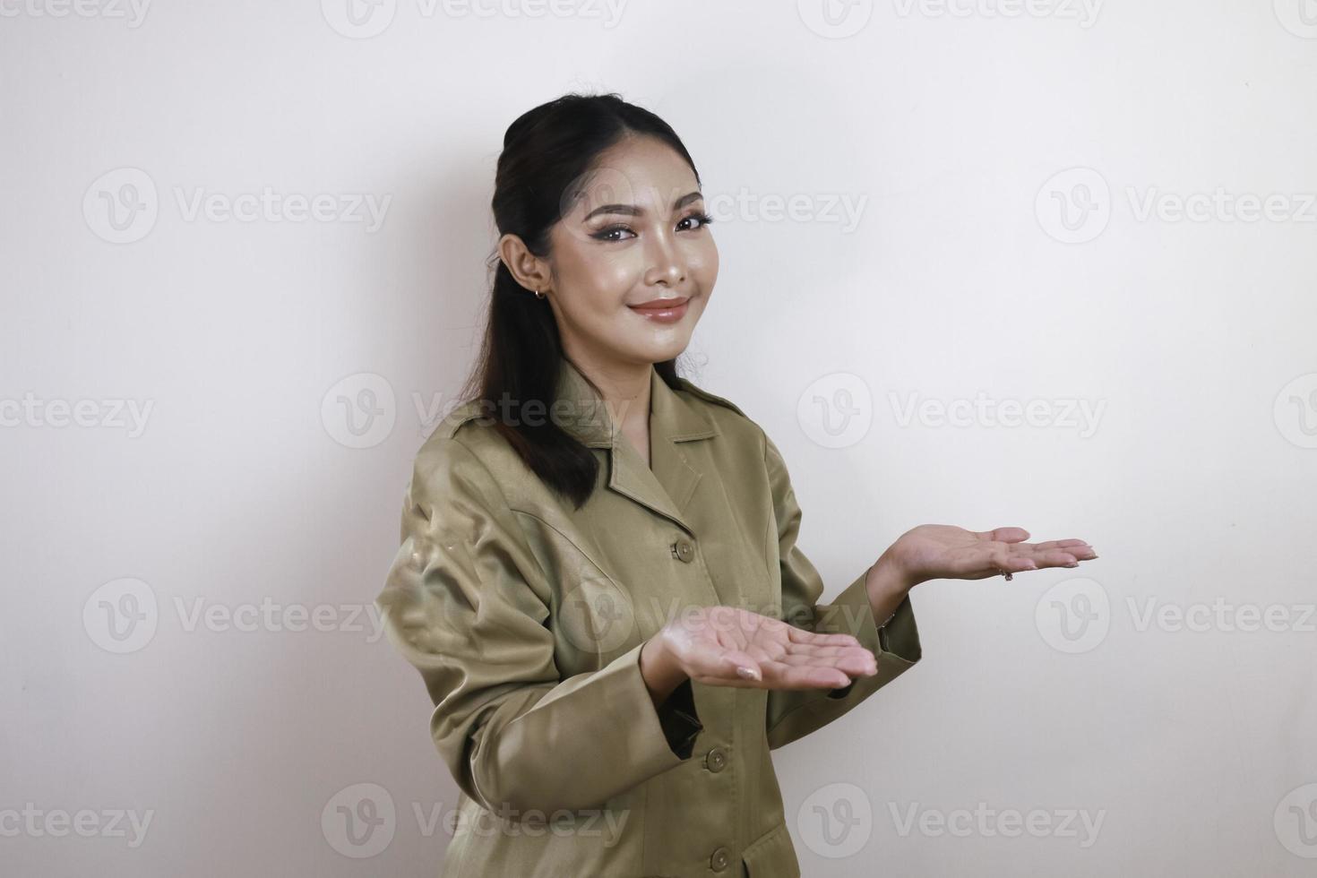 een jonge mooie Aziatische werknemer met een bruin uniform presenteert. Indonesische pn. foto