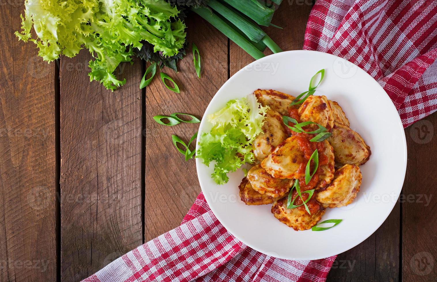 heerlijke ravioli met tomatensaus en groene uien foto