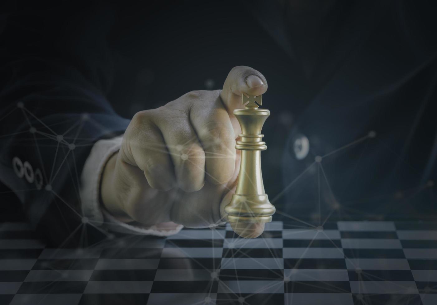 hand van zakenman die het gouden koningsschaak vasthoudt om zilveren koningsschaak te bestrijden om succesvol te spelen in de competitie met technologienetwerkachtergrond. management of leiderschap strategie concept. foto