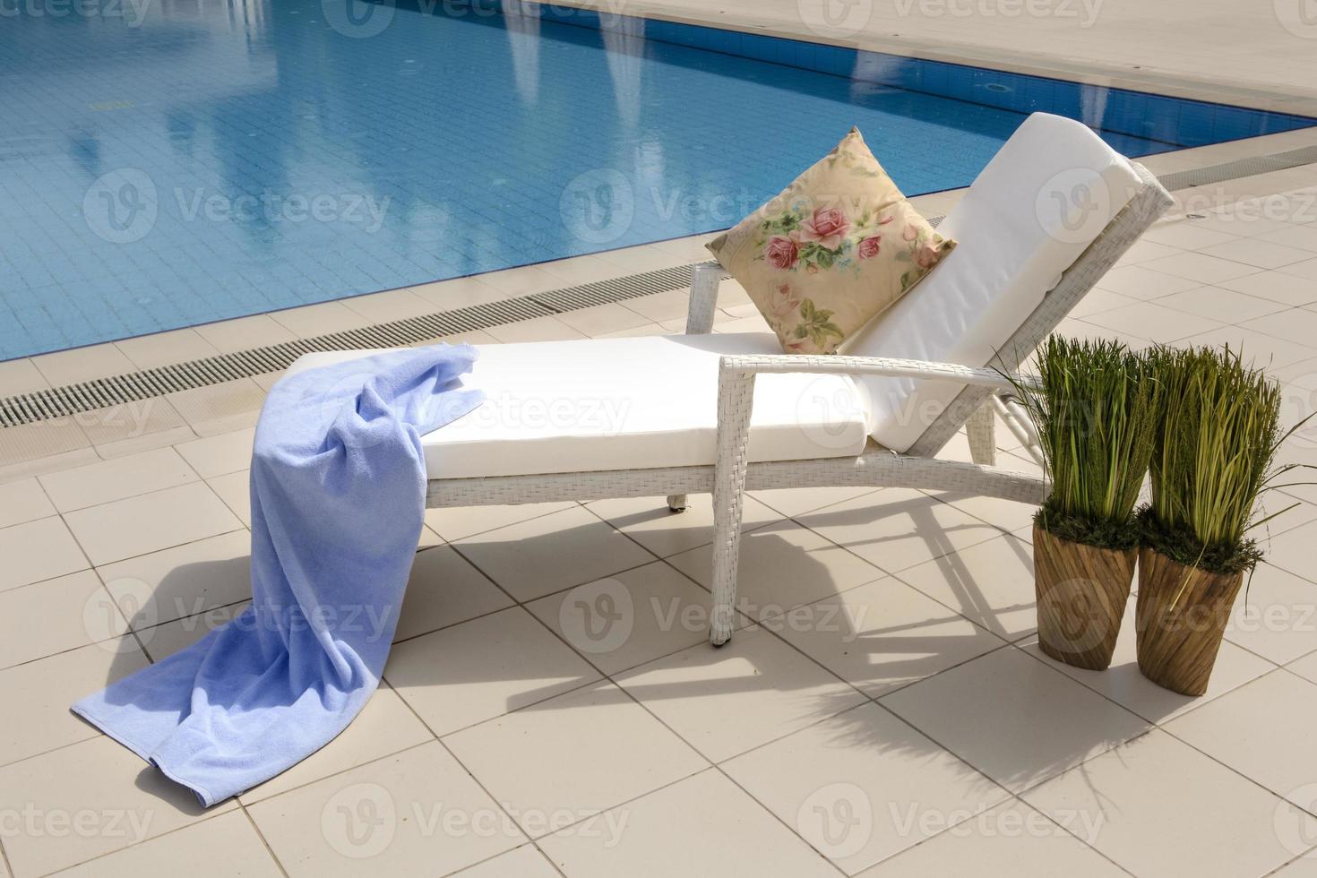 zonnebank naast zwembad in een luxe hotel foto