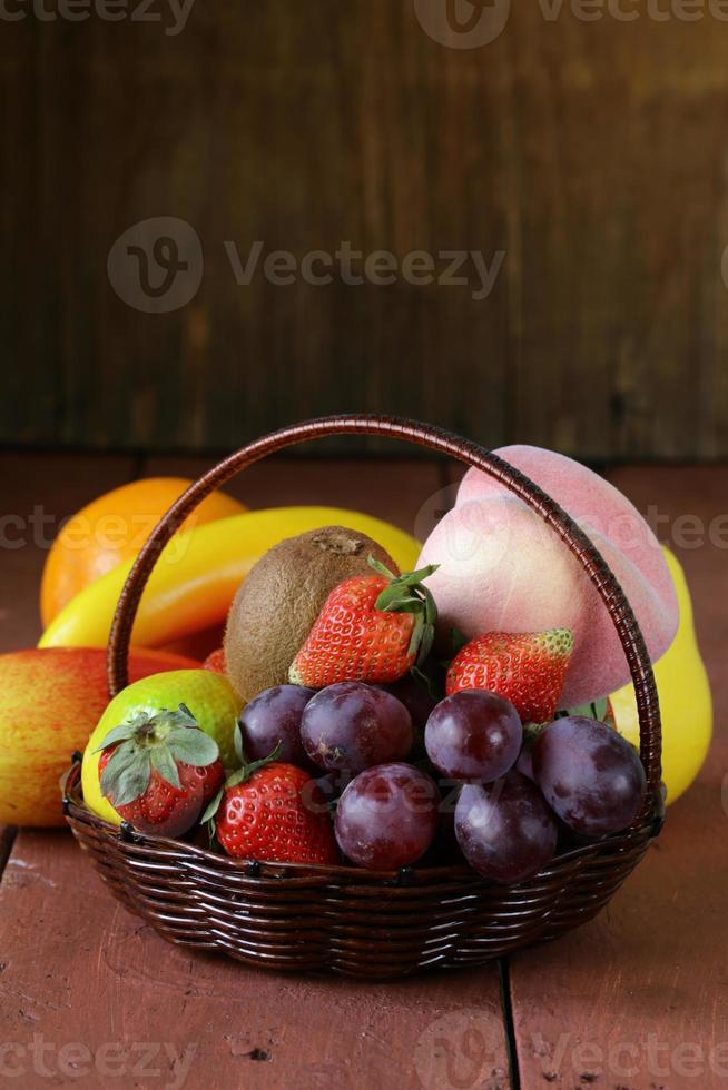 stilleven rieten mand met fruit op een houten tafel foto