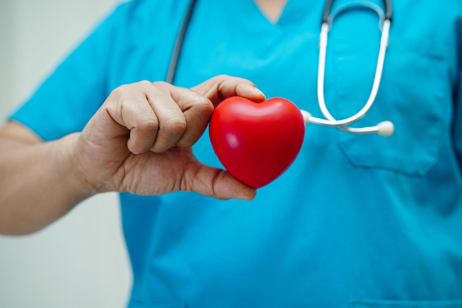 aziatische vrouw arts met rood hart voor gezondheid in het ziekenhuis. foto