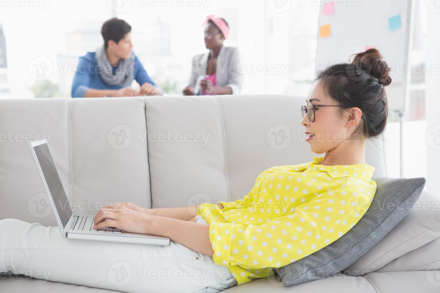jonge creatieve vrouw met laptop op de bank foto