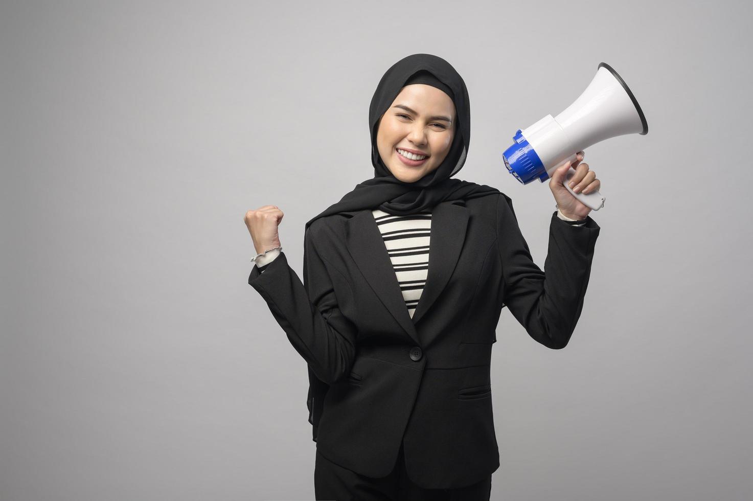 gelukkige moslimvrouw kondigt aan met megafoon op witte achtergrond foto