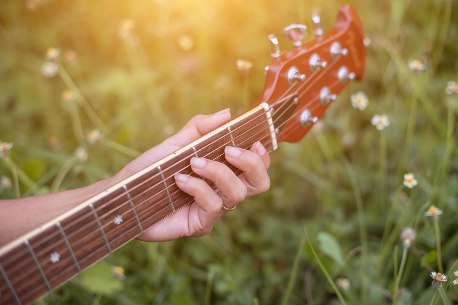 jonge hipster vrouw gitaar spelen om te ontspannen op zijn vakantie, genieten met natuurlijke en frisse lucht. foto