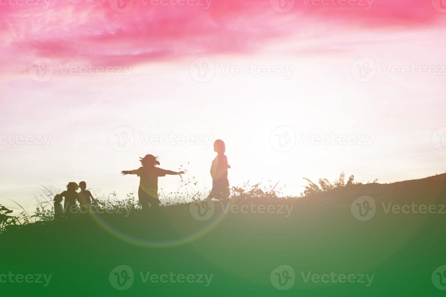 silhouet van een gelukkige kinderen en een gelukkige zonsondergang foto