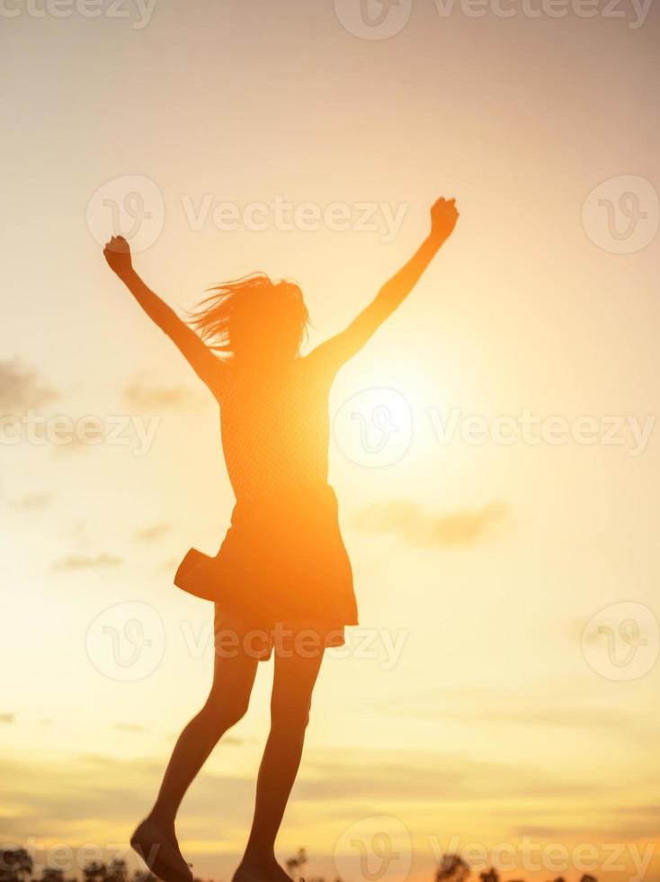 jonge vrouw steekt handen omhoog voor haar succes, concept van succes in het leven. foto