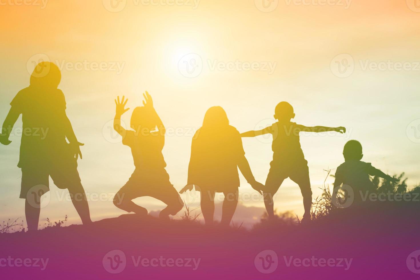 silhouet van een gelukkige kinderen en een gelukkige zonsondergang foto