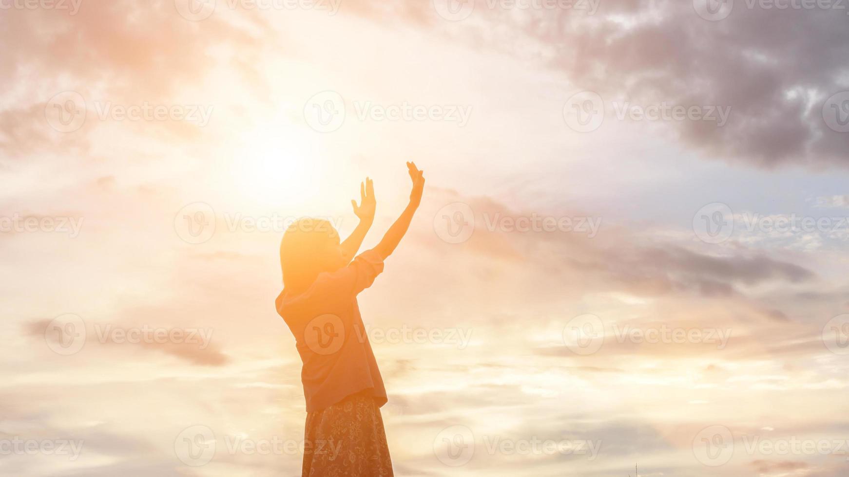 silhouet van een vrouw die bidt over een prachtige hemelachtergrond foto