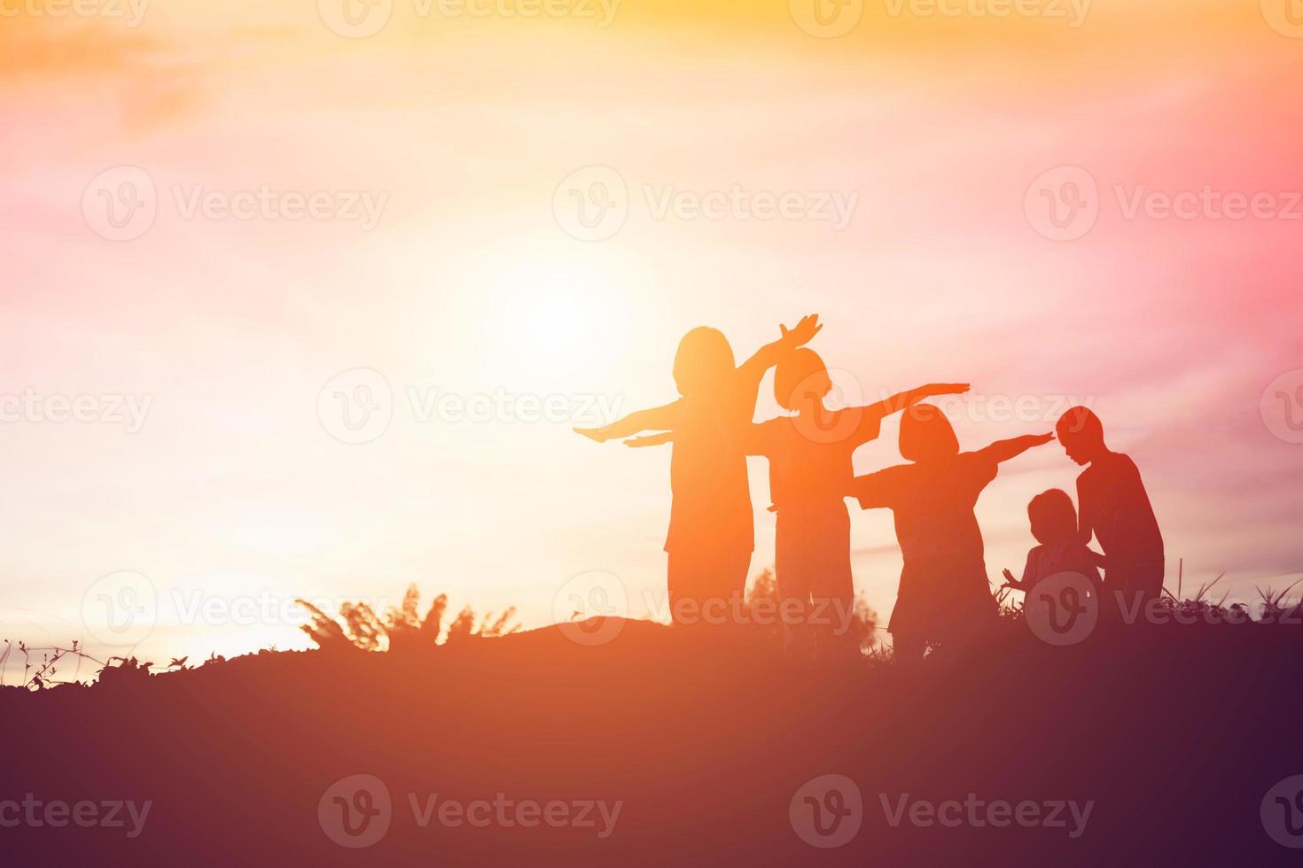 silhouet van een gelukkige kinderen en een gelukkige zonsondergang foto