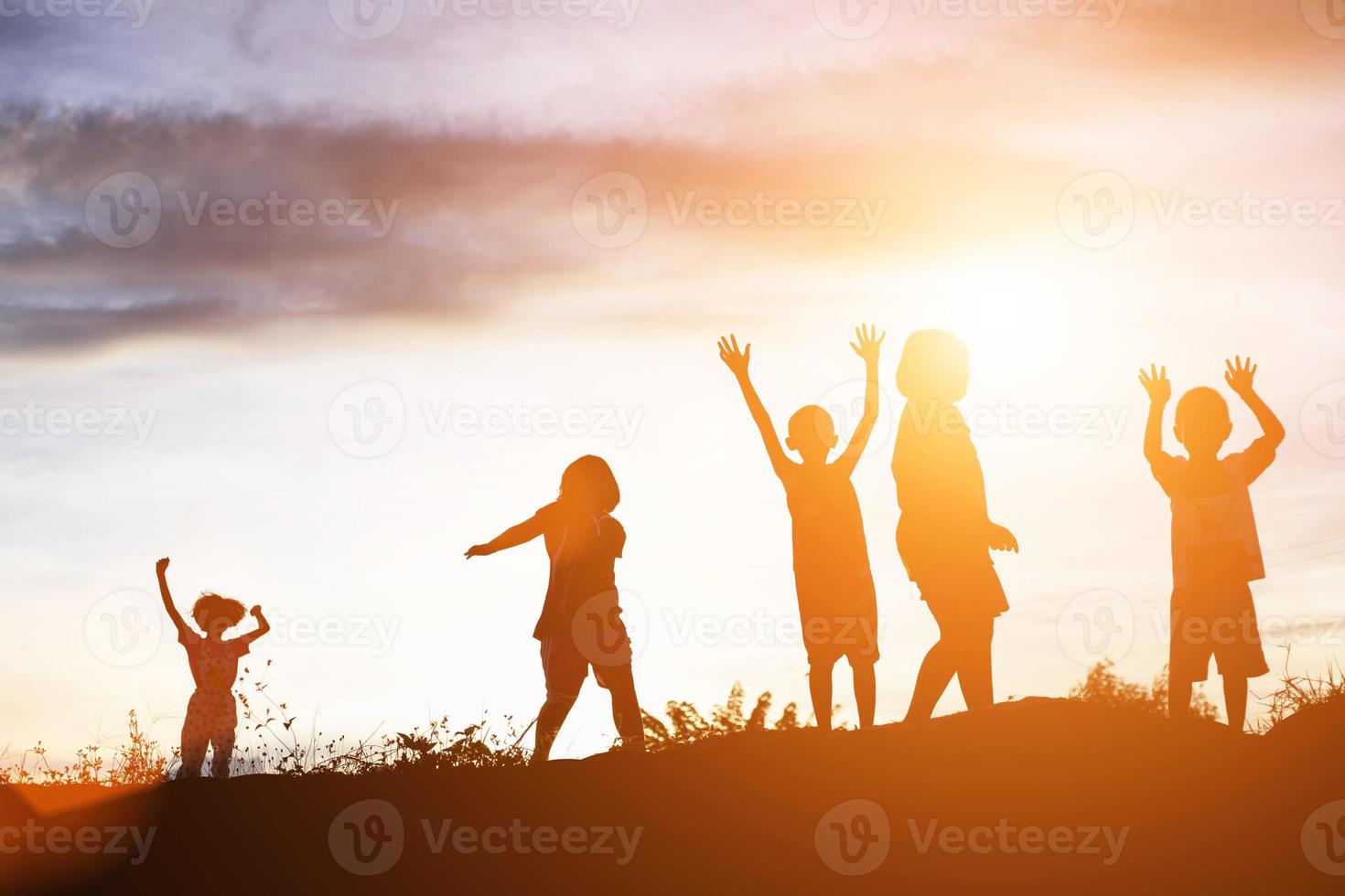 silhouet van een gelukkige kinderen en een gelukkige zonsondergang foto