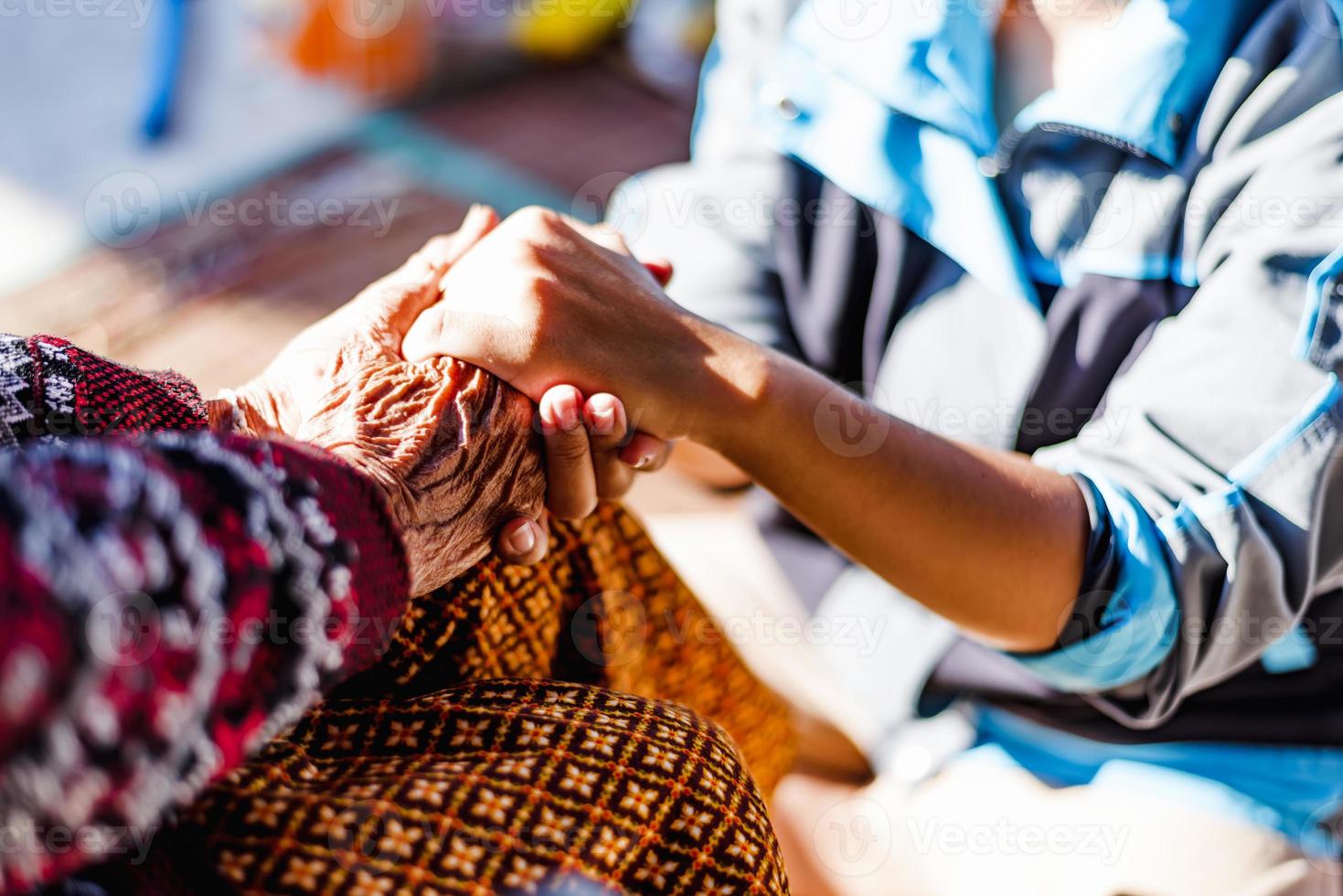 close-up handen van helpende handen ouderen thuiszorg. moeder en dochter. geestelijke gezondheid en ouderenzorg concept foto