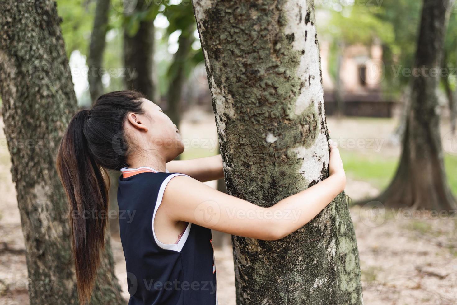 jonge vrouw knuffelen een grote boom, hou van natuur concept. foto