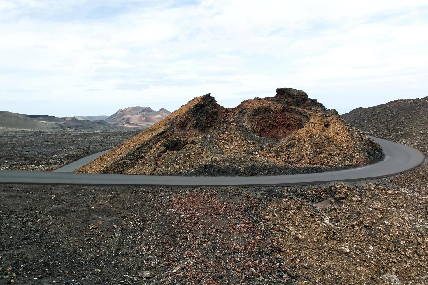 landschap van een uitgestrekt lavaveld. de weg was gemaakt met gestolde lava. lanzarote, canarische eilanden, spanje foto