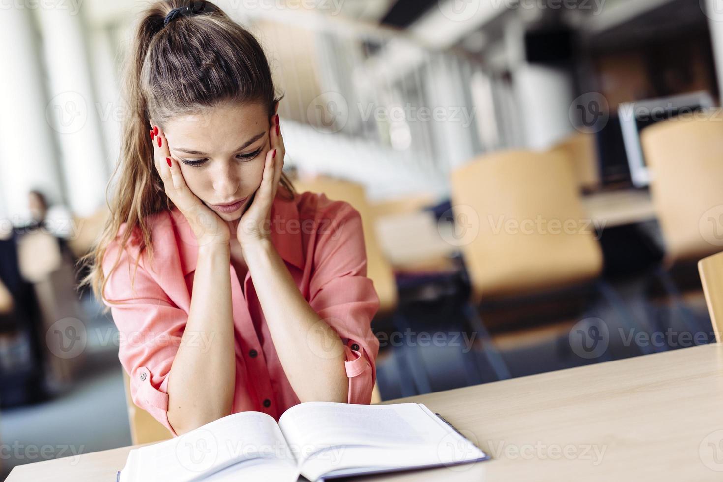 vrouwelijke student studeert in de bibliotheek foto
