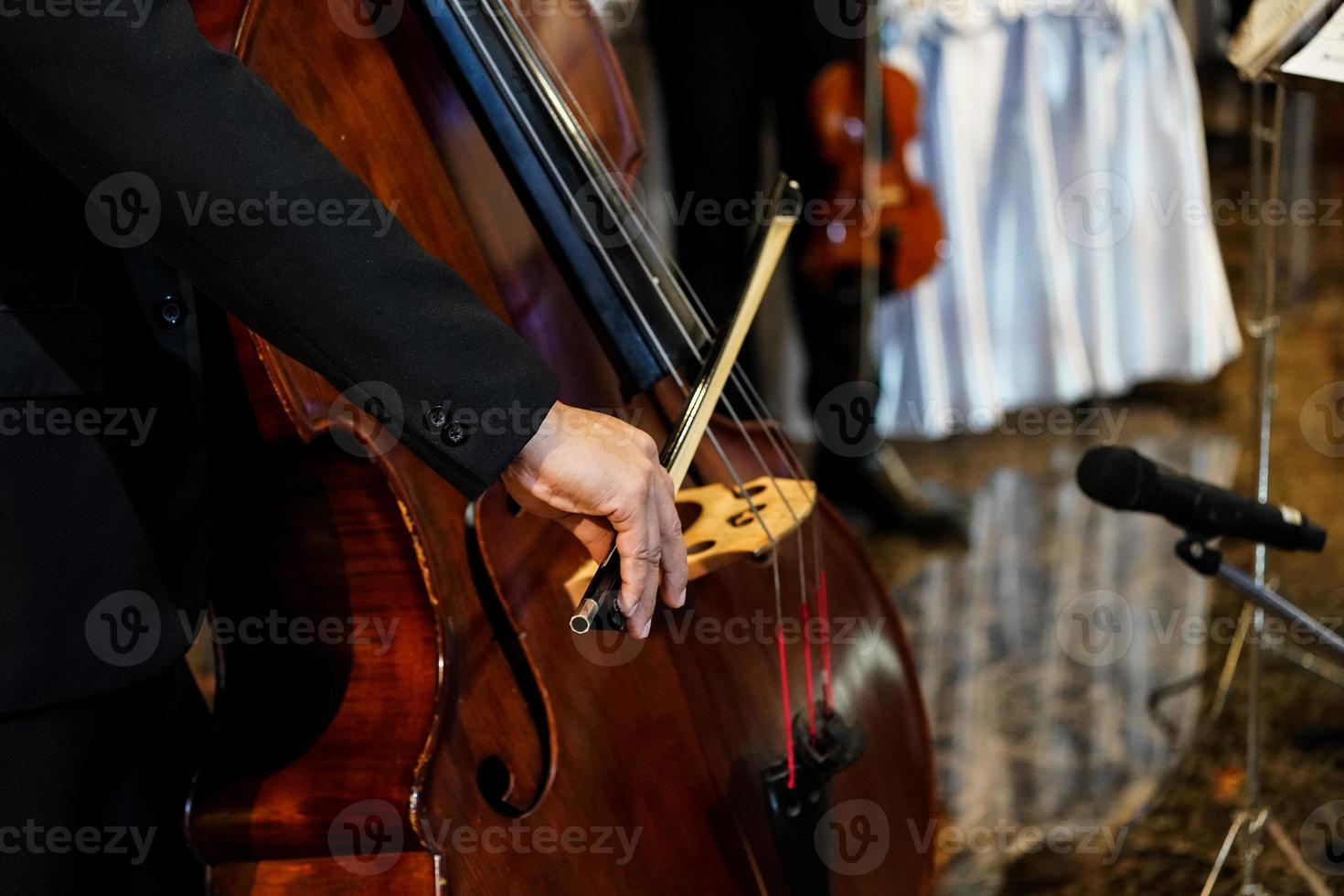 close-up muzikant's hand speelt contrabas in indoor evenement foto