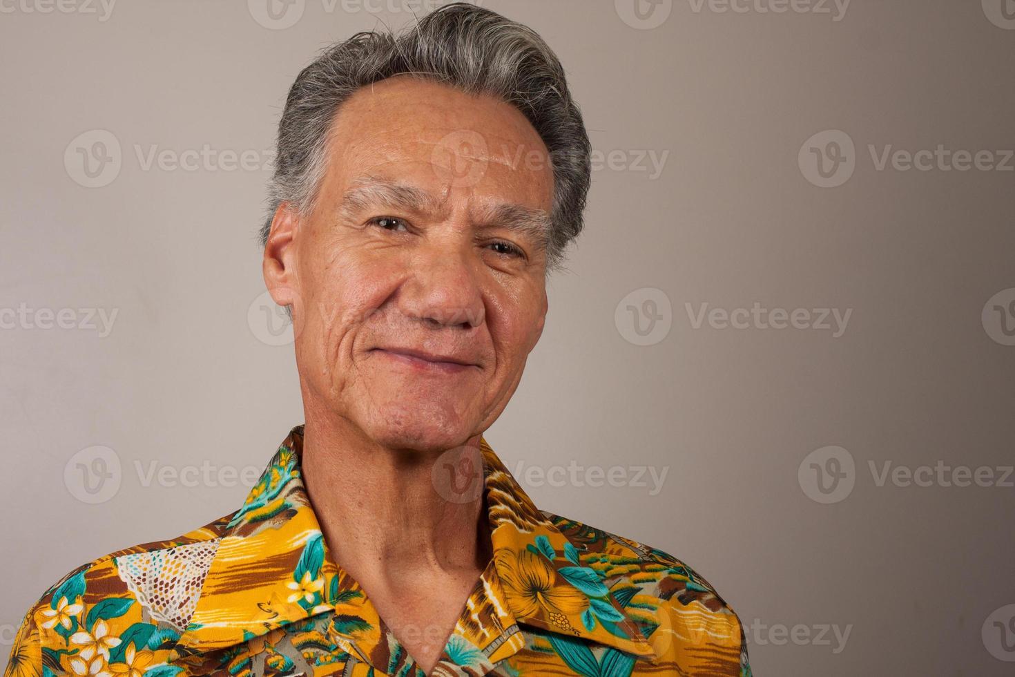hoofd geschoten portret van een volwassen man van 60 plus in een hawaiiaans shirt foto