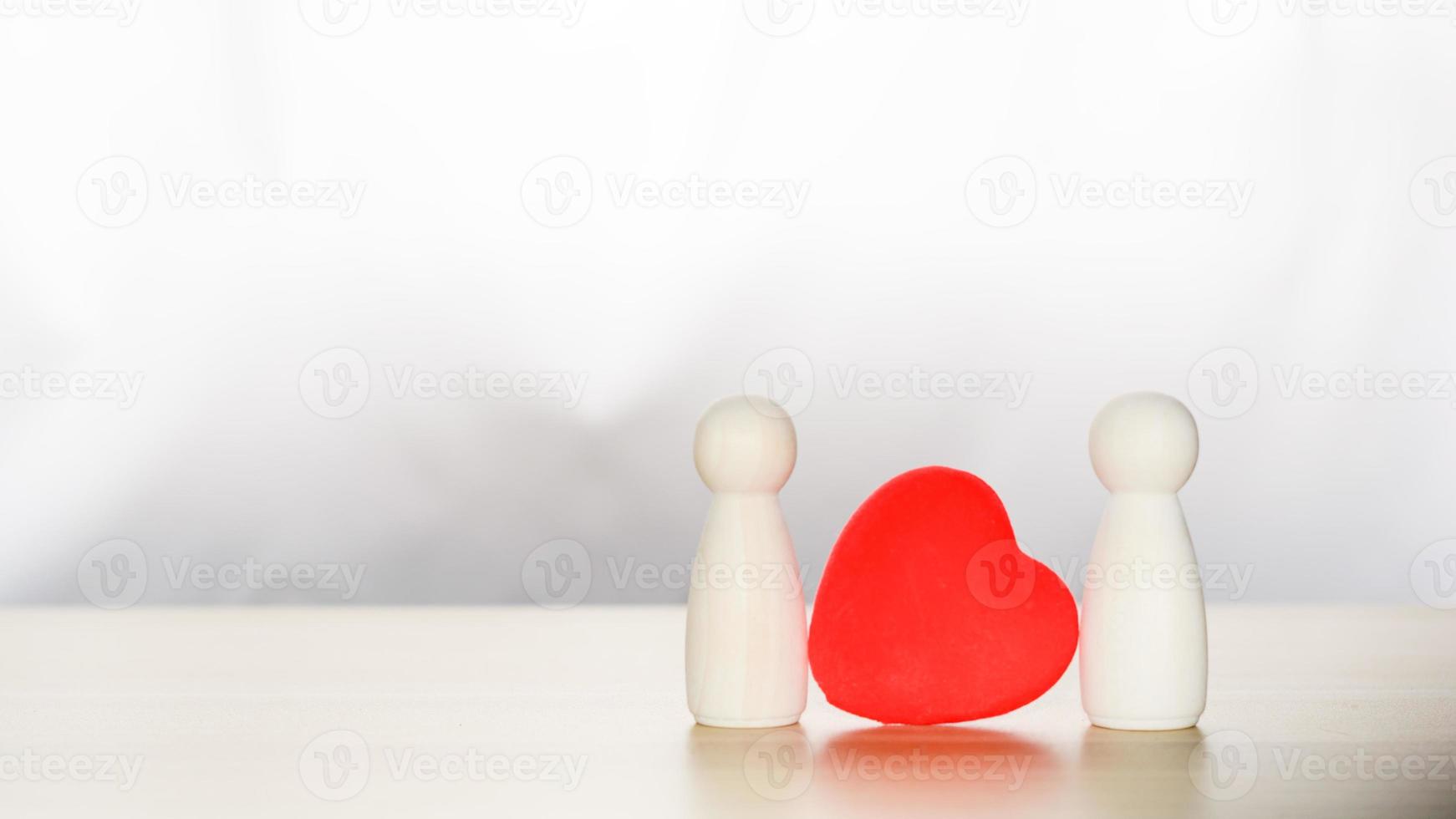 lgbtq-concept. twee verliefde houten figuren staan samen met rode harten. homoseksueel paar. foto