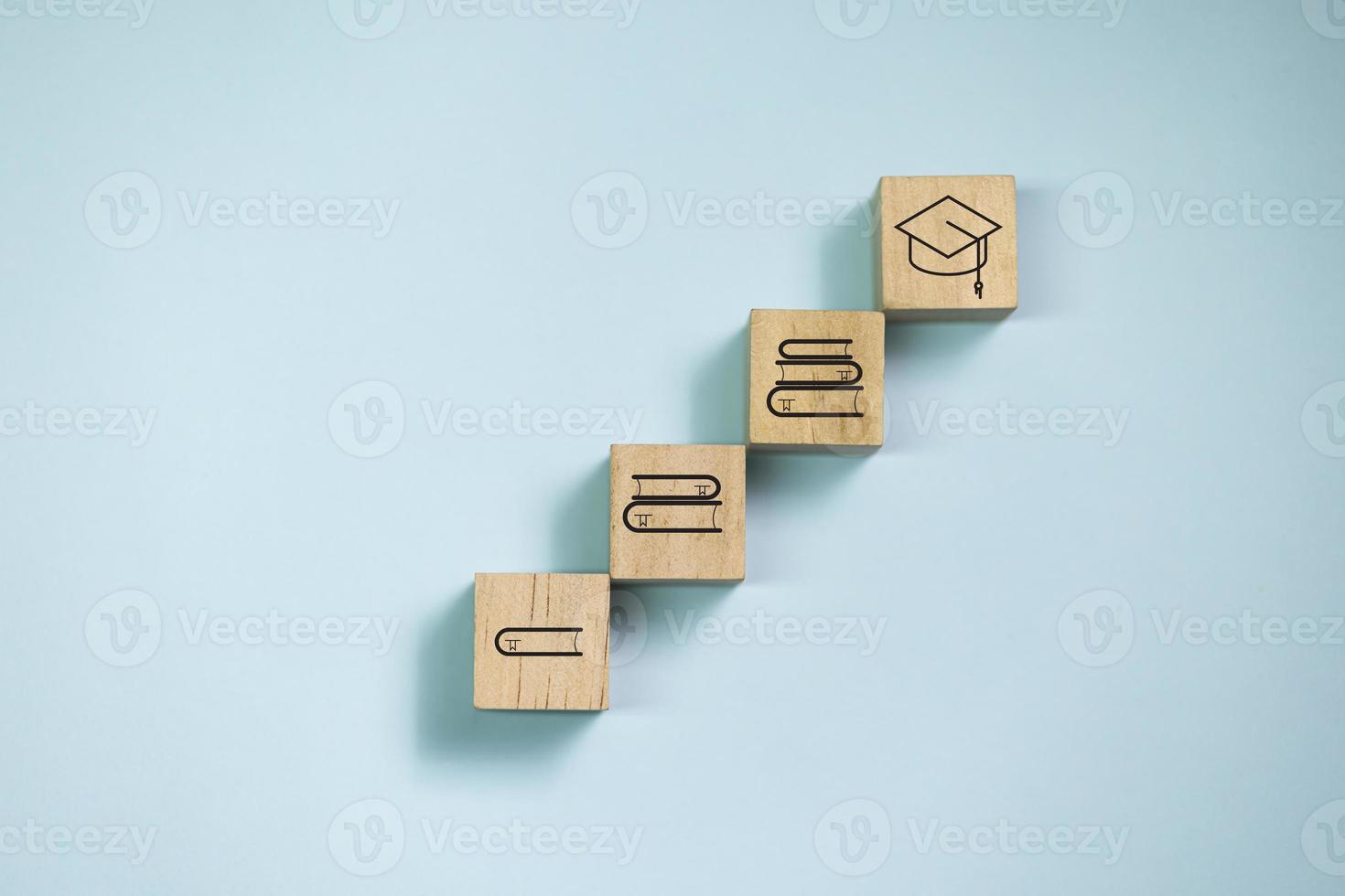 bovenaanzicht houten blokken op stap met boekpictogram om pictogram af te studeren. concept voor leren en onderwijs. foto