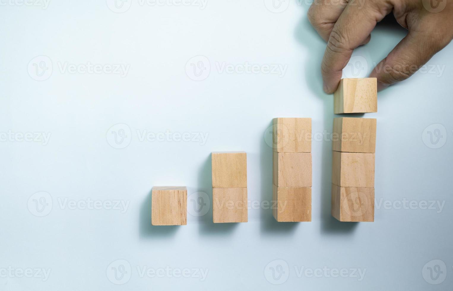 bovenaanzicht handplaats houten blokken ingesteld op groeigrafiek. concept voor geld en succes zaken. foto