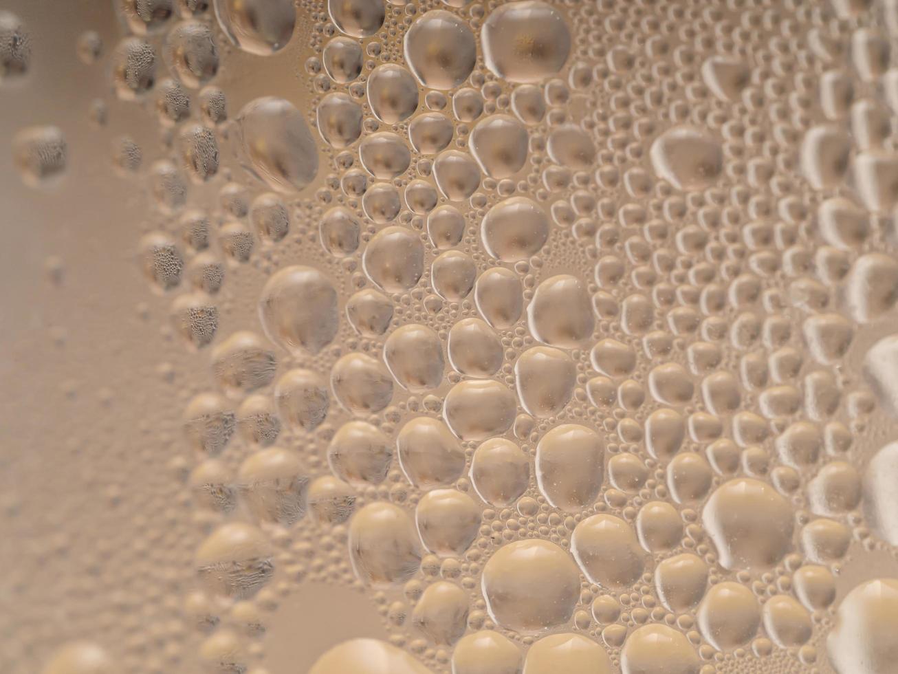 waterdruppels achtergrondstructuur. achtergrond glas bedekt met druppels water. bubbels in water foto