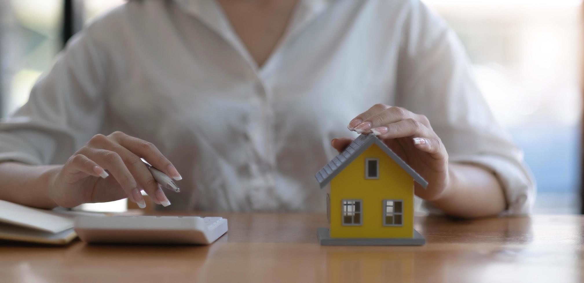 een huis verkopen met verzekering, verkoper of een huizenmakelaar die de prijs berekent om een speciale promotie en gratis verzekering aan te bieden voor klanten die een modelwoning kopen. foto